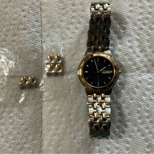 Men’s Citizens quartz watch with two tone gold and silver band.